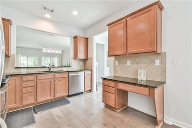 Kitchen with dishwasher, light wood-style floors, a sink, decorative backsplash, and recessed lighting