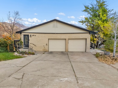 View of property exterior with brick siding, a garage, and concrete driveway