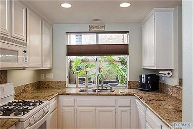 Remodeled kitchen with slab granite and granite ba