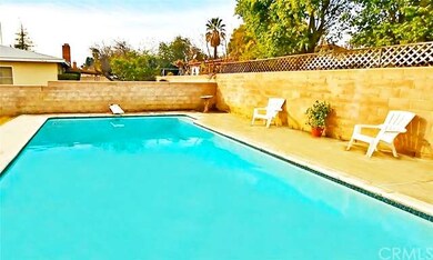 Block wall surrounds the backyard with a pool!