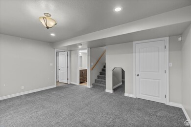 Finished below grade area featuring carpet, stairs, and recessed lighting