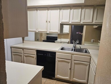 Kitchen with light tile patterned floors, sink, an