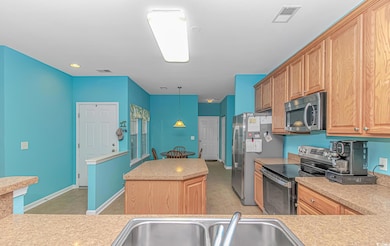 Kitchen with visible vents, a kitchen island, ligh