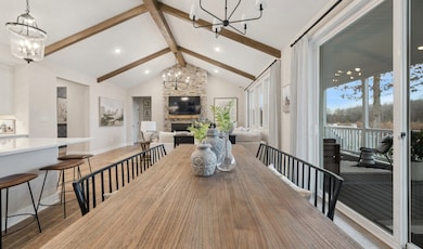 Dining area with stained ceiling beams & vaulted ceiling