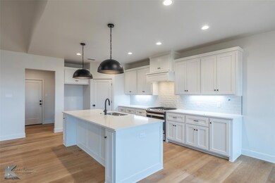 Kitchen with pendant lighting, sink, white cabinet