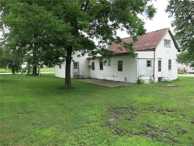 Back of house with a patio area, a yard, and a metal roof