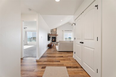 Hall with lofted ceiling, plenty of natural light, light wood finished floors, and recessed lighting