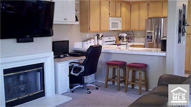 OPEN FAMILY ROOM WITH FIREPLACE LOOKING INTO KITCH