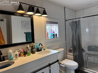 Full bath with tiled shower, toilet, vanity, tile patterned floors, and a baseboard heating unit