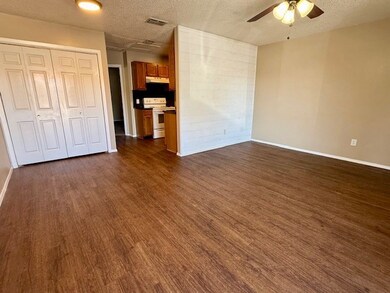 Unfurnished bedroom featuring a textured ceiling, dark wood-type flooring, a closet, and ceiling fan