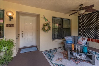 View of exterior entry with stucco siding and a ceiling fan
