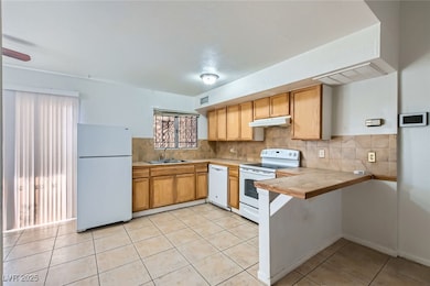 Kitchen with white appliances, tile countertops, u