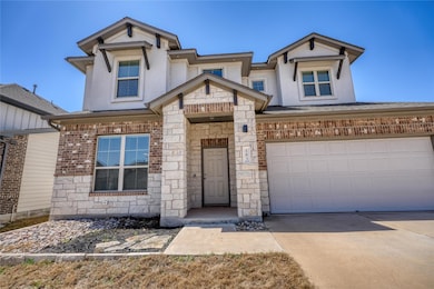 View of front of house with stone siding, stucco 