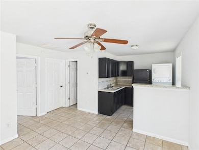 Kitchen with estacked washer and dryer, dark cabin