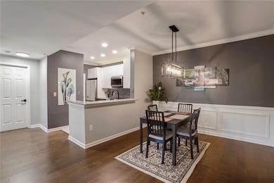 Dining area featuring crown molding, dark wood finished floors, recessed lighting, baseboards, and a chandelier