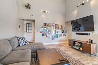Living area featuring light wood-type flooring and a high ceiling