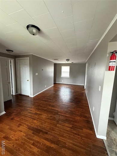 Unfurnished room with wood finished floors and crown molding