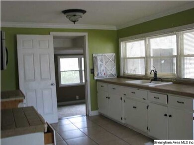 The kitchen has a travartine tile floor and tile c