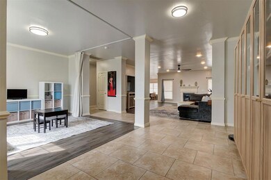 Foyer entrance featuring crown molding, ornate col