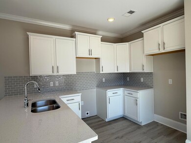Kitchen featuring visible vents, ornamental moldin