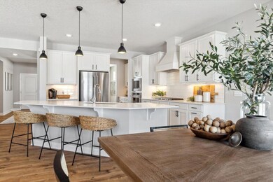 Welcome to the Whitney floor plan and the kitchen of your dreams! Stunning wood hood, gas cooktop, built in wall oven and convection microwave. Photo of a model home, color & options will vary.