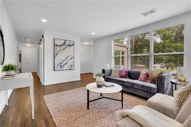 Living area featuring dark wood-style floors, baseboards, a barn door, and recessed lighting