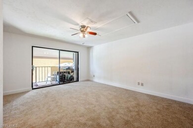 Spare room with light carpet, attic access, and a ceiling fan