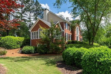 View of side of home with brick siding, a chimney,