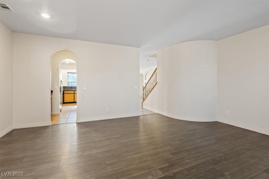 Spare room featuring arched walkways, wood finishe