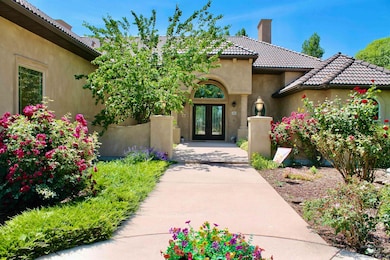 Entrance to property featuring french doors, a chimney, stucco siding, and a tile roof