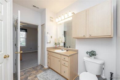 Bathroom featuring vanity, toilet, and ceiling fan