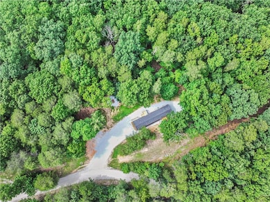 Aerial view of property and surrounding area with a forest