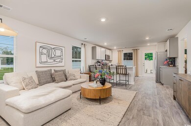 Living area with light wood-style floors and recessed lighting