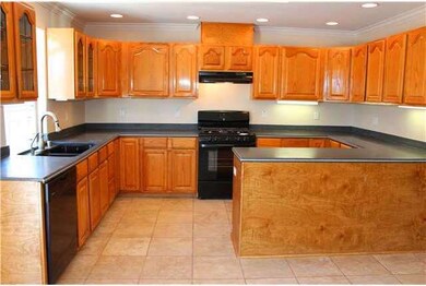 Large and bright kitchen has corian counter tops, 