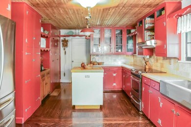 Chef's kitchen with wood plank ceiling and hardwoo