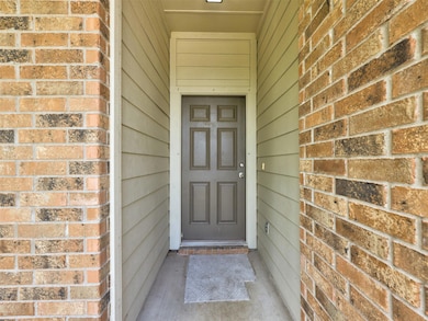 View of exterior entry featuring brick siding