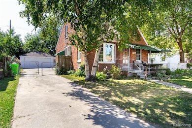 View of front of house with an outdoor structure, a garage, and brick siding