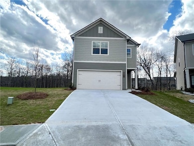 View of front of home featuring concrete driveway, board and batten siding, an attached garage, and a front lawn