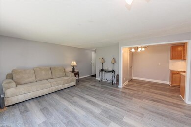Hardwood floored living room featuring an inviting chandelier