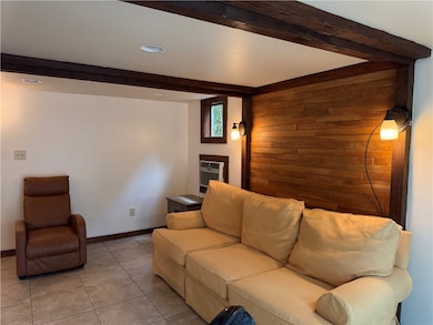Tiled living room featuring wooden walls, beam ceiling, recessed lighting, and a wall mounted air conditioner