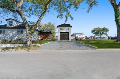 View of front facade featuring driveway and a front lawn