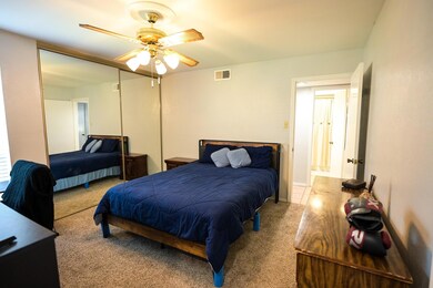 Bedroom featuring light carpet, ceiling fan, and a