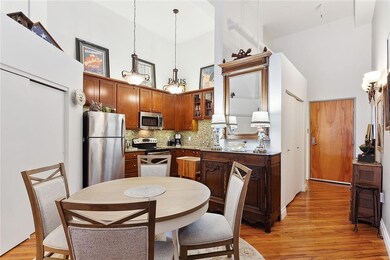 Looking to the front door and kitchen, there is a very nice dining table - the closed doors in the hall of this photo hide the full-size washer/dryer. The bathroom is to the left of the front door to the unit.