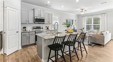 Kitchen with sink, light stone counters, gray cabi