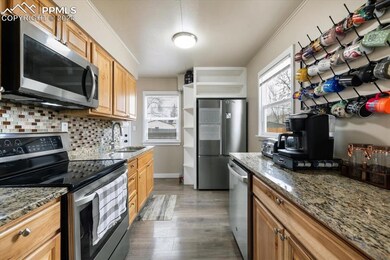 Kitchen with stone counters, sink, stainless steel