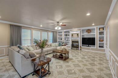 Living room with a ceiling fan, built in features,