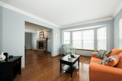Front living room with crown molding, gleaming har