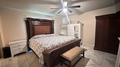 Bedroom with light marble finish floors and ceiling fan