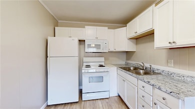 Kitchen with white appliances, a sink, white cabin