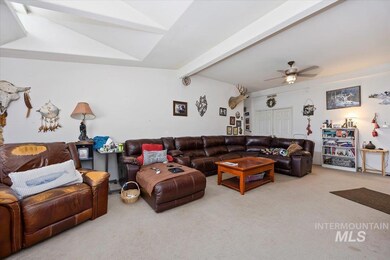 Carpeted living area featuring ceiling fan